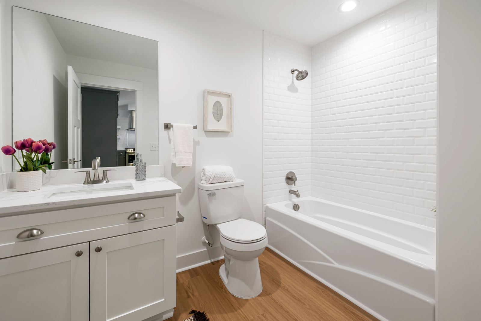 Clean white bathroom with tub and vanity